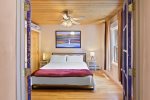 King bed with ceiling fan and natural light